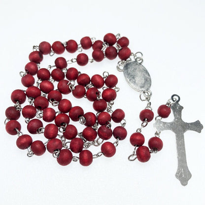 Rosario de madera roja visto por detrás de la medalla y la cruz
